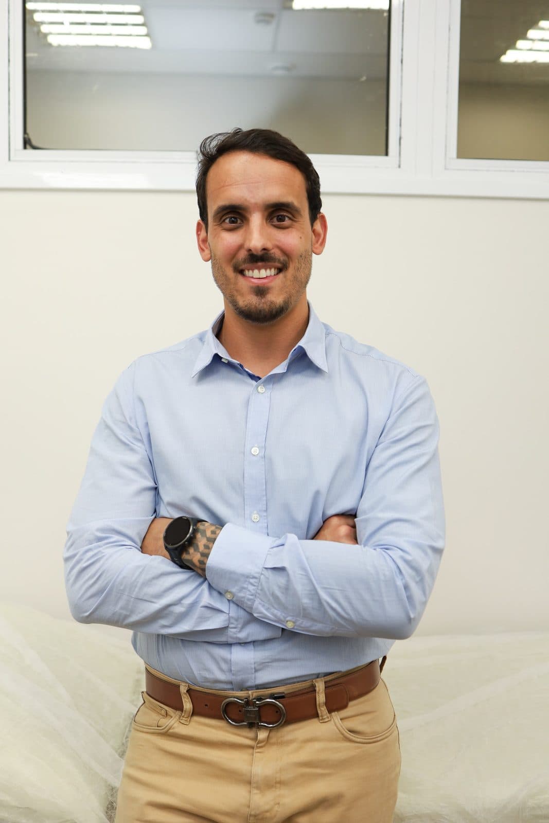Dr. Pedro Barreto de braços cruzados, sorrindo, no consultório